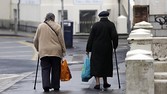 Elderly women use walking sticks as they carry shopping bags on a street in Folkestone, UK, on Tuesday, April 9 2013