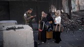 An Israeli border police officer checks documents of Palestinian women on their way to pray at the Al-Aqsa Mosque in Jerusalem during the Muslim holy month of Ramadan at the Qalandia checkpoint, between the West Bank city of Ramallah and Jerusalem, Friday, July 4, 2014. (AP Photo/Majdi Mohammed)