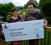 Joe and Karen McLoughlin holding giant cheque.