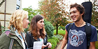 Three students chatting on campus