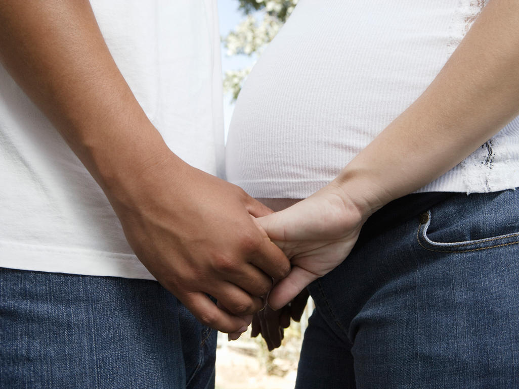 Pregnant couple holding hands