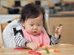 Little girl eating with her hands