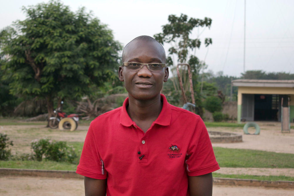 School teacher smiling in school playground in Côte d'Ivoire .