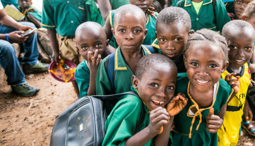 School children in Sierra Leone smile at the camera.