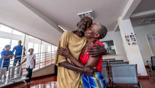 A man and woman embrace following successful surgery.