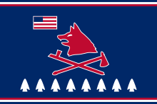 Pawnee Nation tribal flag in red white and blue featuring a stylized wolf and a U.S. flag, a hatchet crossed with a pipe, and eight arrow heads