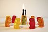 six little gummy bears gathered in a circle to burn a seventh gummy bear at the stake