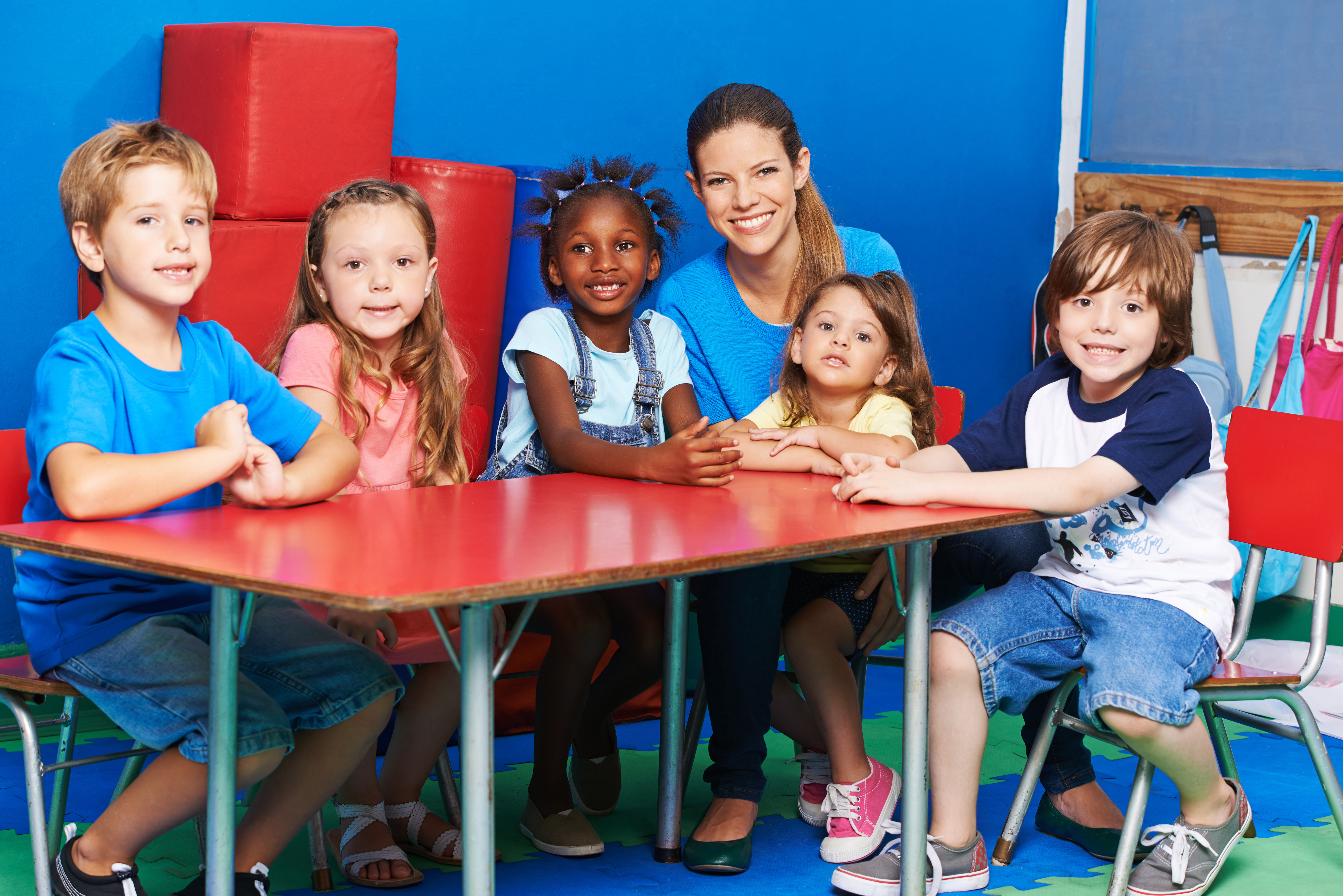 Early educator and children at a table