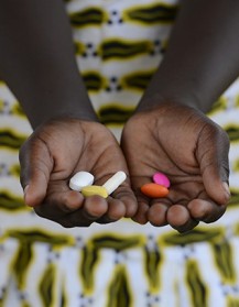 A girl holds a handful of pills