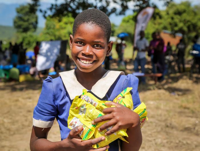 smiling girl holding packs of food