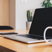 Tips voor thuiswerken: MacBook, iPhone en meer op bureau.