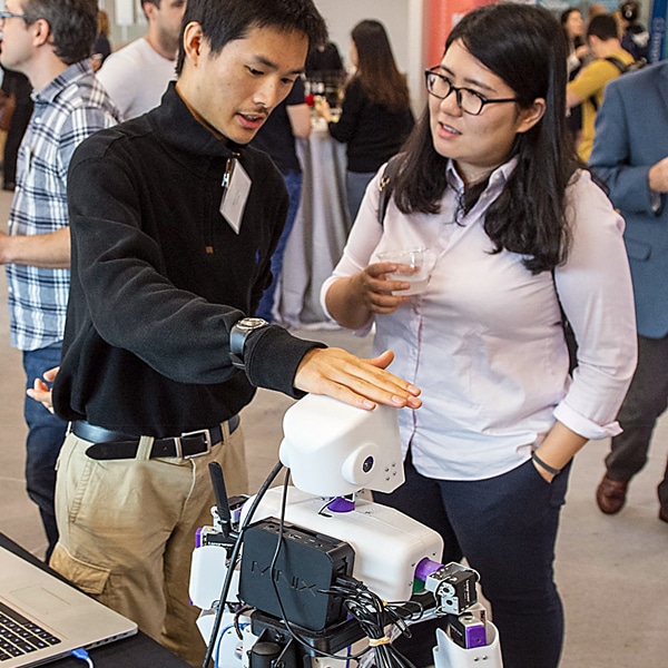 student showing a robot to another student