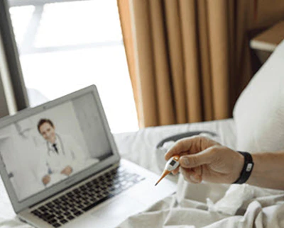 Male nurse supporting a patient in a hospital room.