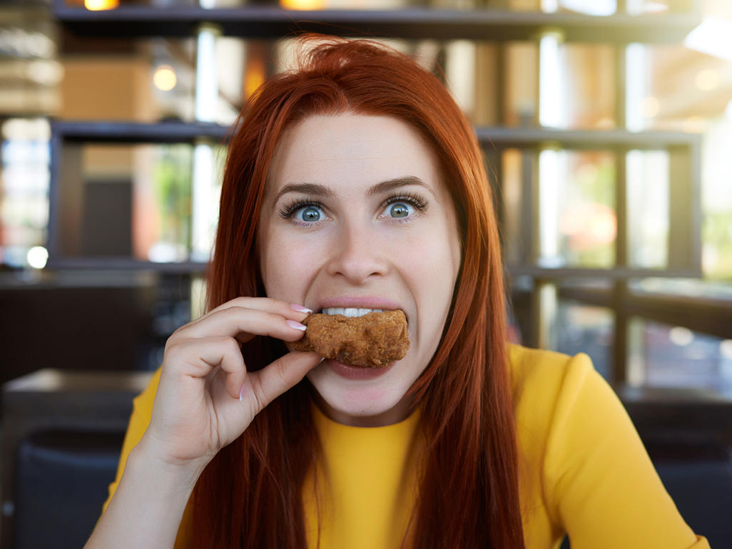 woman with a piece of food in her mouth