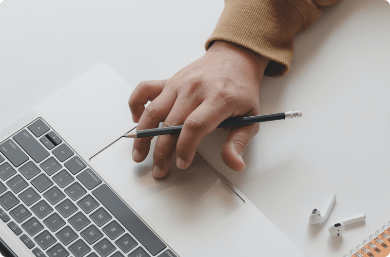 A hand on a computer taking notes