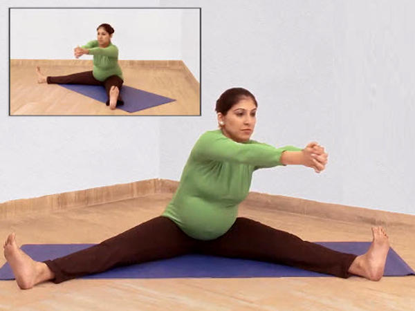 Pregnant woman doing the churning the mill yoga pose