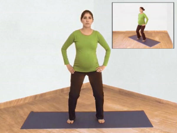 Pregnant woman doing the hip rotation yoga exercise