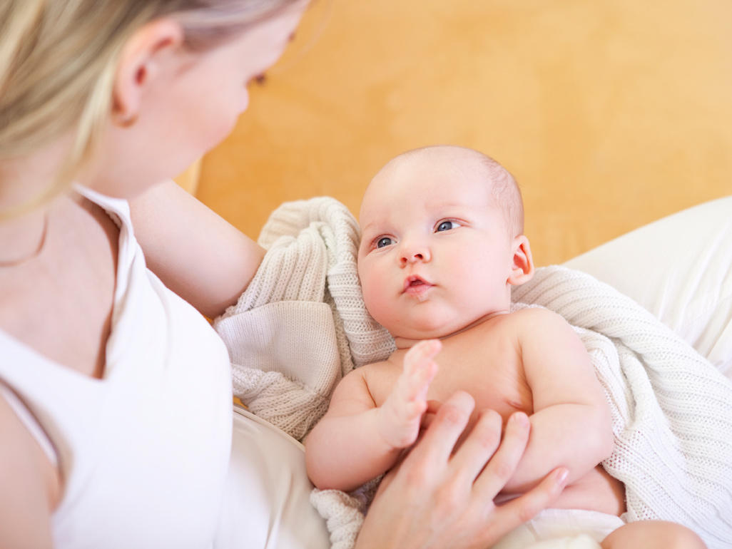 Mum looking lovingly at baby on her lap