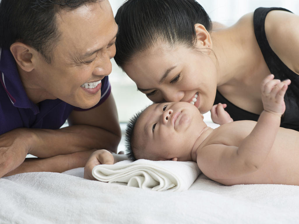 parents smiling at their new born baby