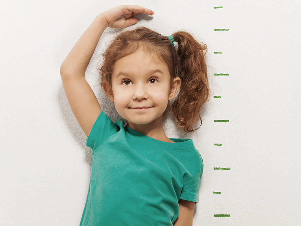 young girl measuring her height