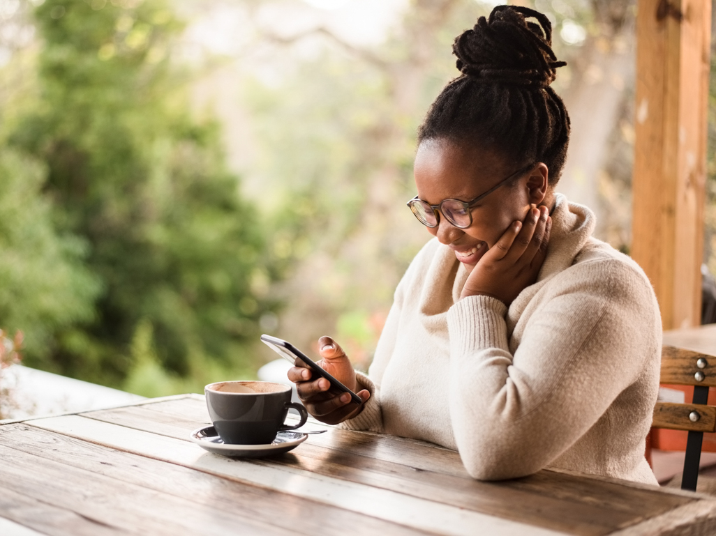 woman smiling looking at her phone