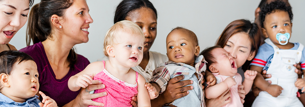 Babies of different ethnicities with a parent.