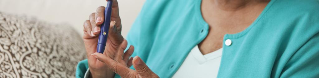 Image of woman using a glucose monitor to measure blood sugar and represent Diabetes Prevention