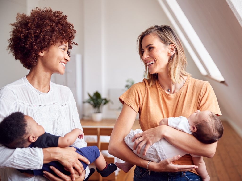 two moms holding their babies