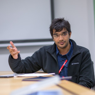 Student gesturing with hand in workshop