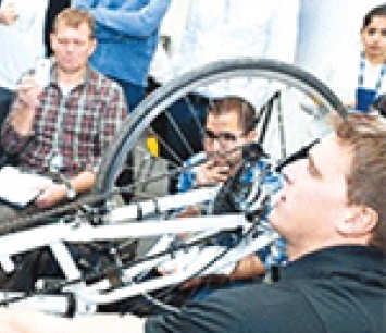 Three students looking at a bike derailleur