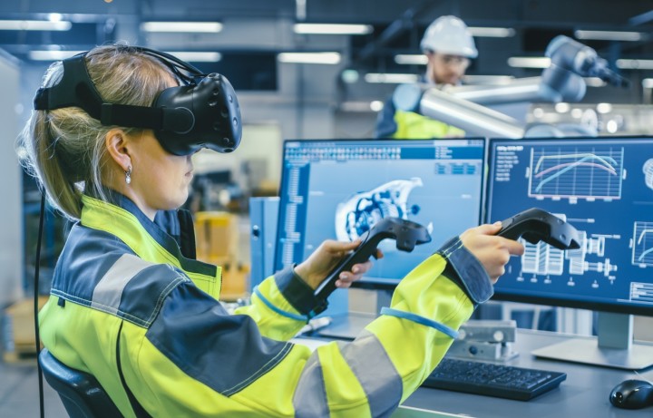 A woman engineer using VR goggles and hand pieces