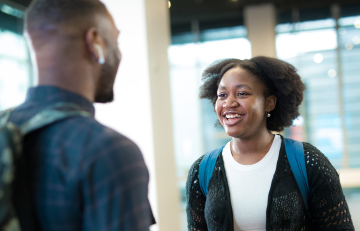 Two students standing in main entrance talking