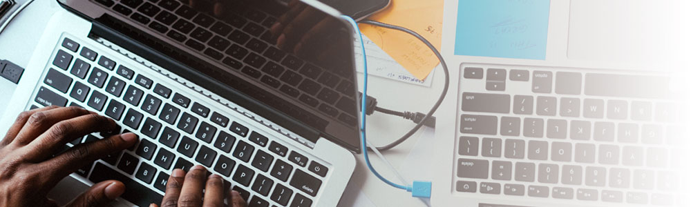 A laptop computer and wires on a desk