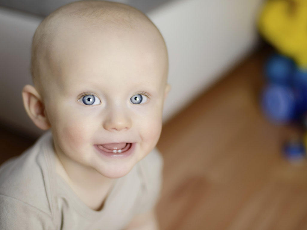 Fast zahnloses Baby lächelt in die Kamera