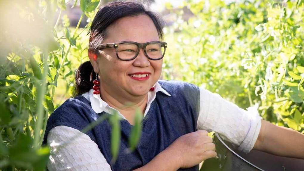 Diep Tran holds a pot in a farm's field.