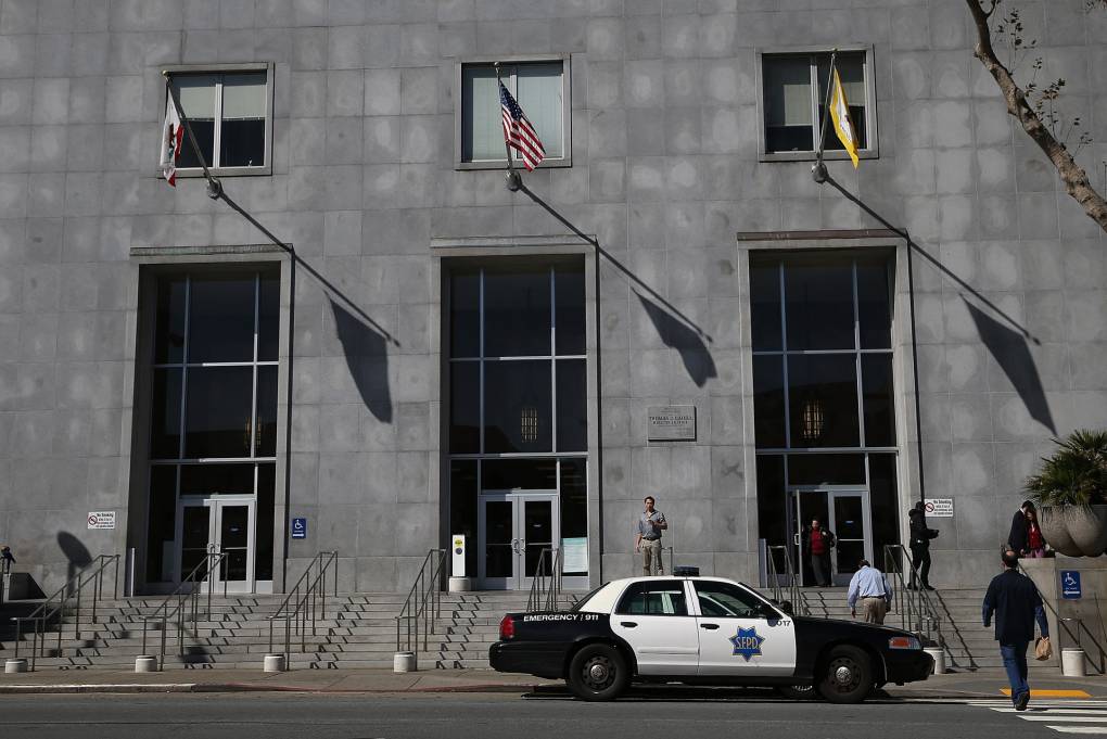 A large stone building with a police car in front.