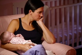 image of a mother holding a baby and looking out the window