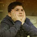 Adolescent male looking out a window