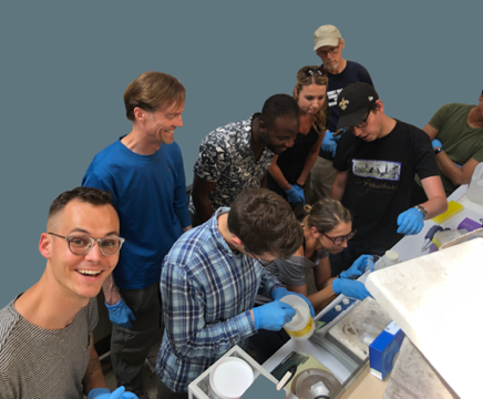 A group of people gathered around a lab workbench.