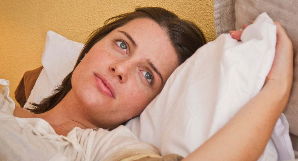 Woman looking pensive in bed