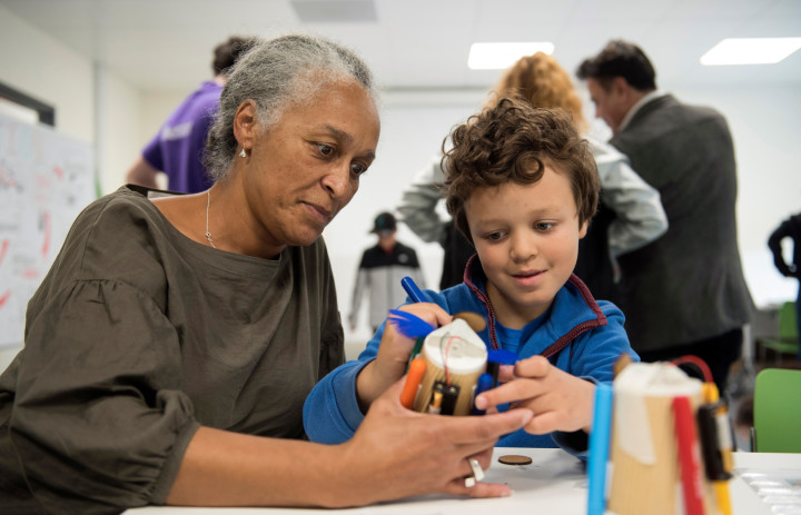 A woman and child making robots out of coffee cups