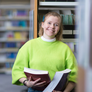 A student in our Central Library holding books