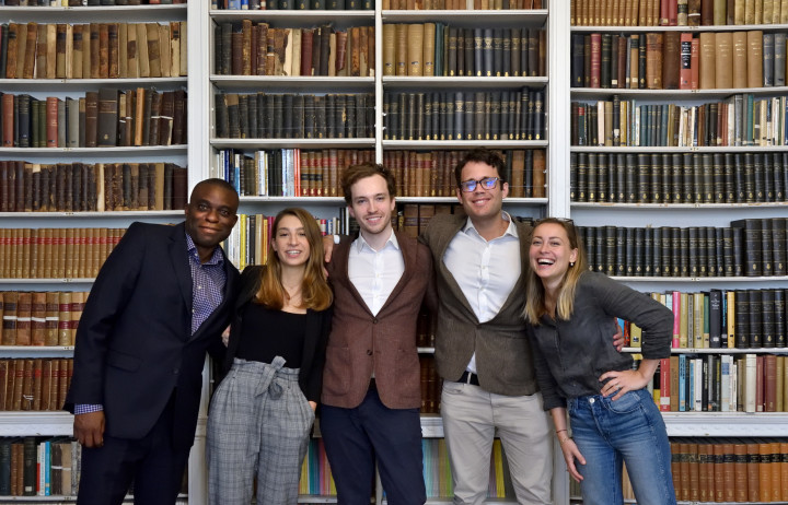 Greenhouse cleantech accelerator team Mana Biosystems stand in a group in front of bookcases