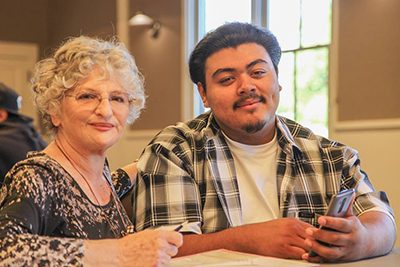 High School Student Helping Senior Citizen with Phone