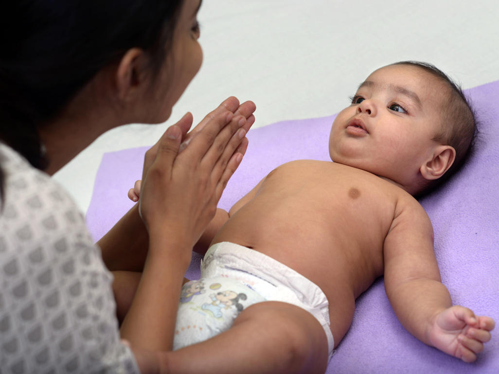 Mum smiling at baby during massage