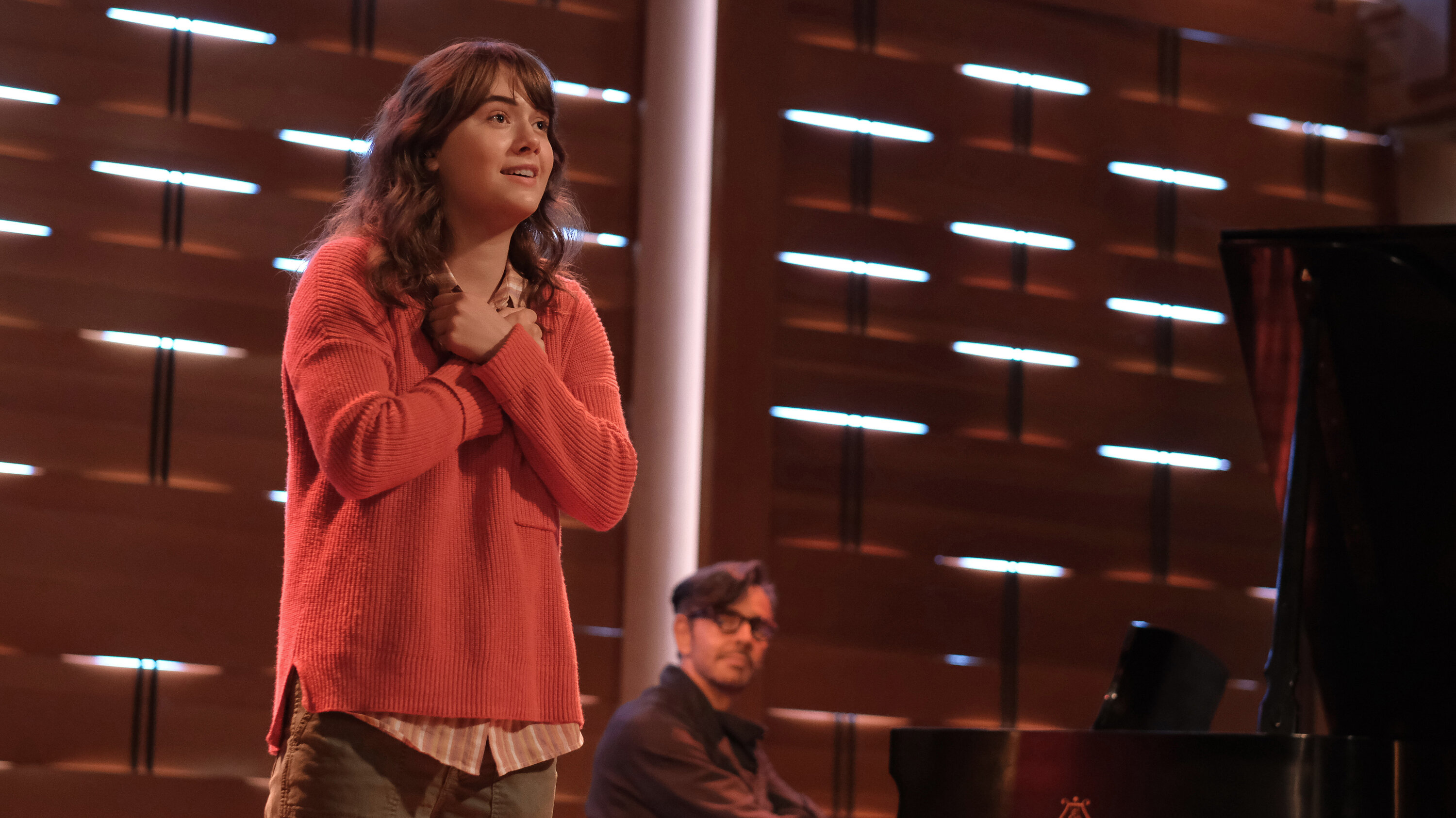 Emilia Jones (with Eugenio Derbez at the piano) plays a hearing teenager whose desire to sing confounds her family. Critics say they are confounded by the film’s depiction of the relationship between deafness and music.