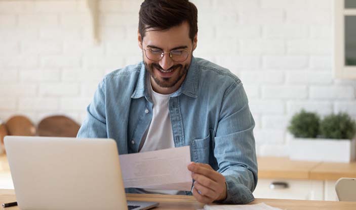 Illustrasjonsfoto. Smilende mann som leser et dokument