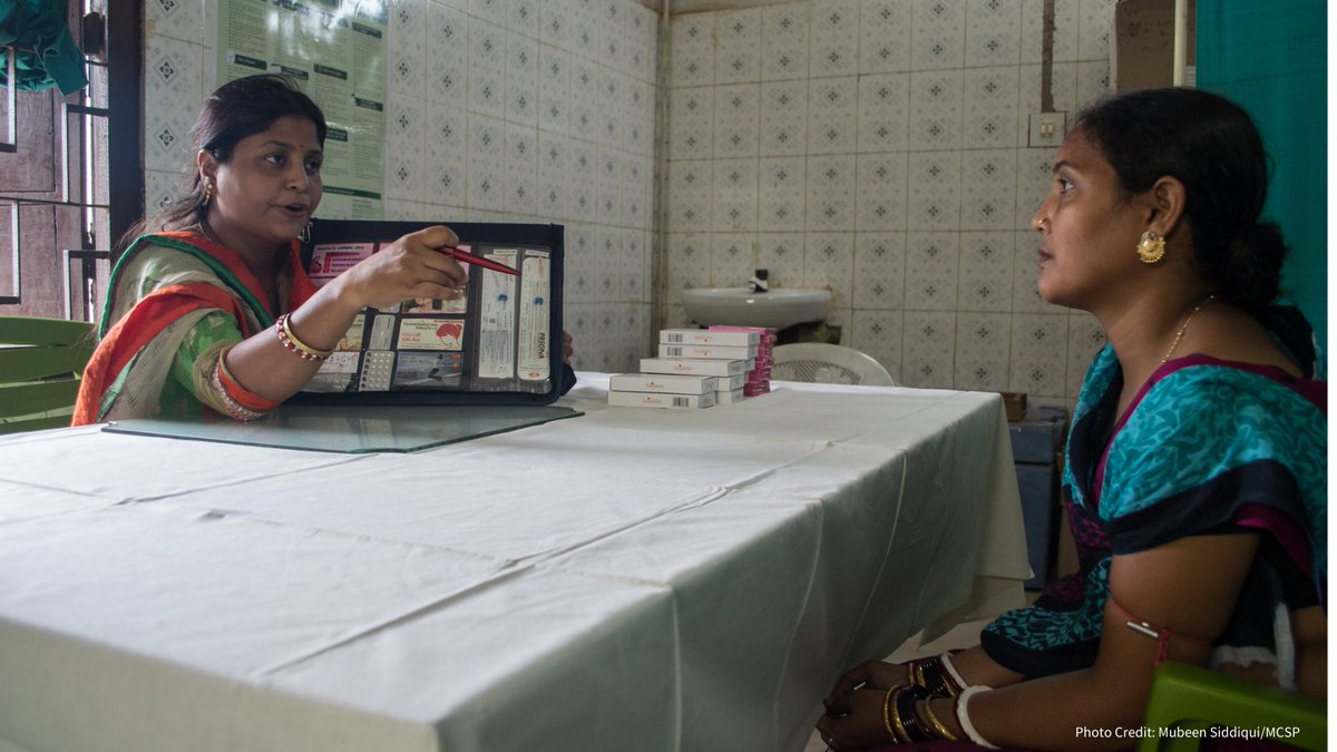 A woman client receives counseling on methods of contraception available in a clinic, from a female counselor who is showing her a kit of products.  