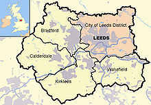 Leeds district (pink),other four metropolitan boroughs of West Yorkshire (clockwise from Leeds: Wakefield, Kirklees, Calderdale and Bradford). County and borough boundaries are black, urban areas grey, motorways blue with white stripe, rivers and bodies of water light blue. A Great Britain inset map shows West Yorkshire highlighted.