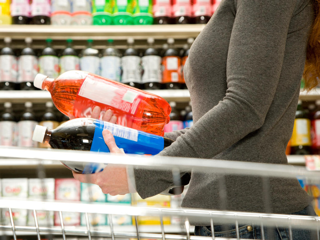 woman holding two liters of soda